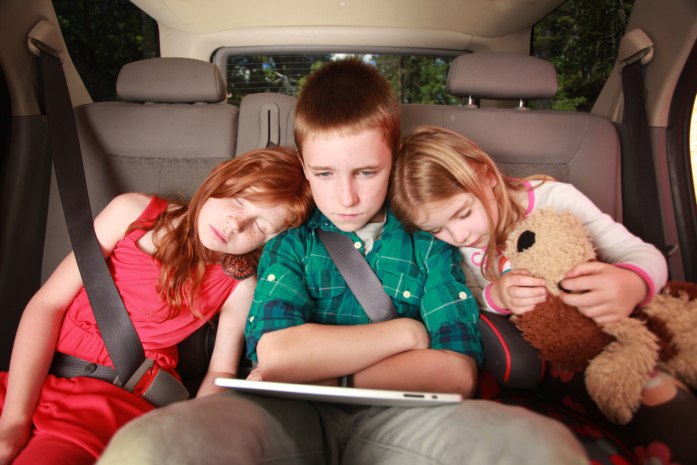kids-watching-a-movie-on-a-tablet-in-the-back-of-a-car